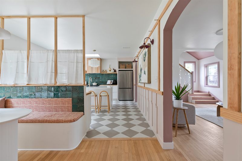 Open kitchen with green tile, a built-in banquette, checkerboard floor and a slatted wood screen